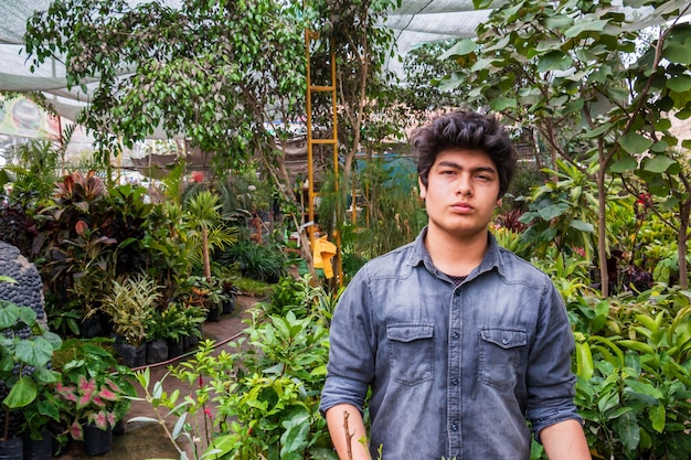 Jovem proprietário de jardim masculino cultivando plantas no conceito de empresário de pequenas empresas com efeito de estufa