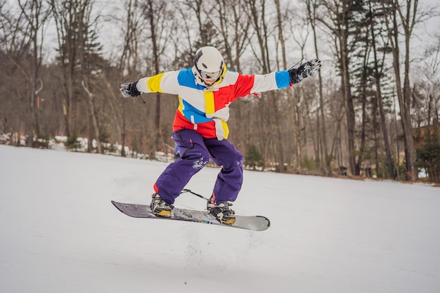 Jovem pulando com uma prancha de snowboard nas montanhas