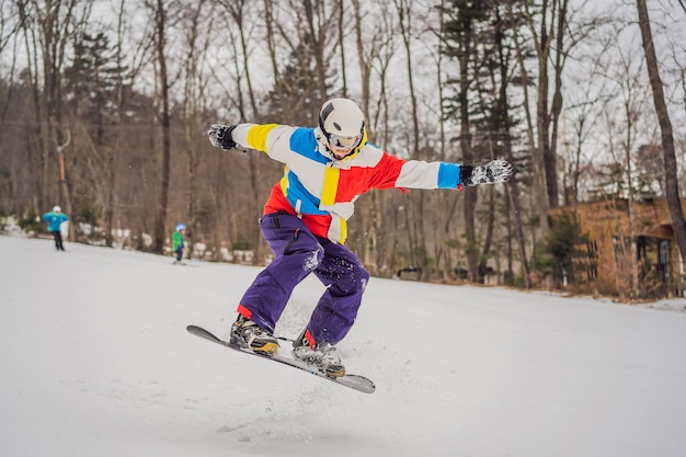 Jovem pulando com uma prancha de snowboard nas montanhas