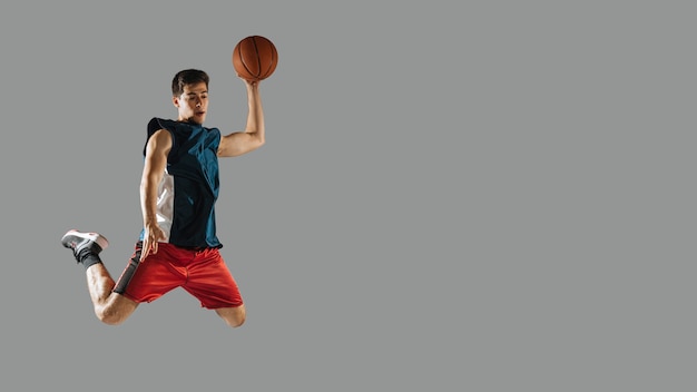 Foto jovem pulando enquanto estiver jogando basquete com espaço de cópia