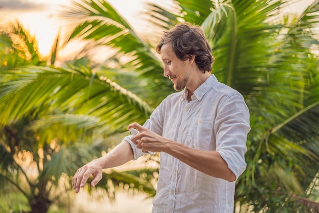 Foto jovem pulverizando repelente de mosquitos na proteção contra insetos da floresta