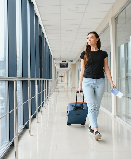 Foto jovem puxando mala no terminal do aeroporto copiar espaço