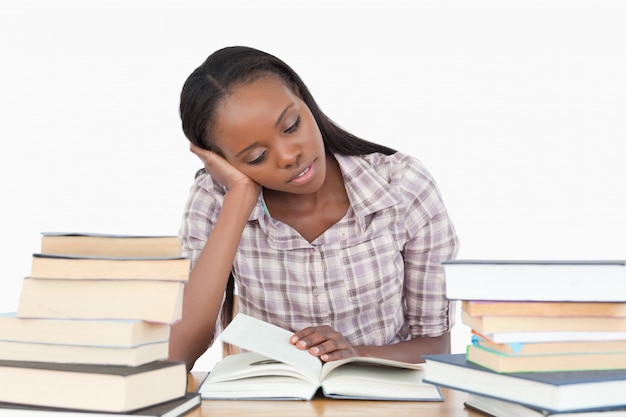 Foto jovem quase adormecendo durante a leitura