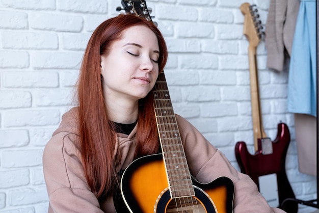 Jovem que toca violão em casa