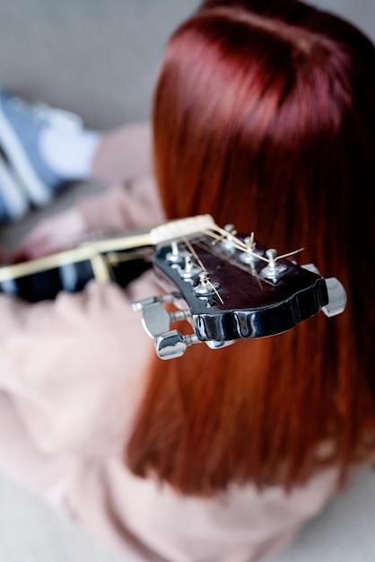 Jovem que toca violão em casa