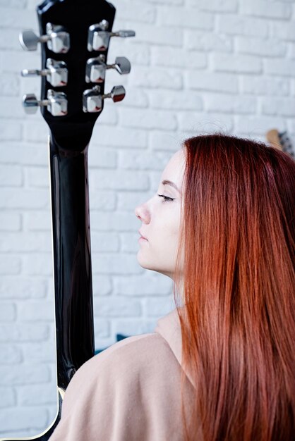 Jovem que toca violão em casa