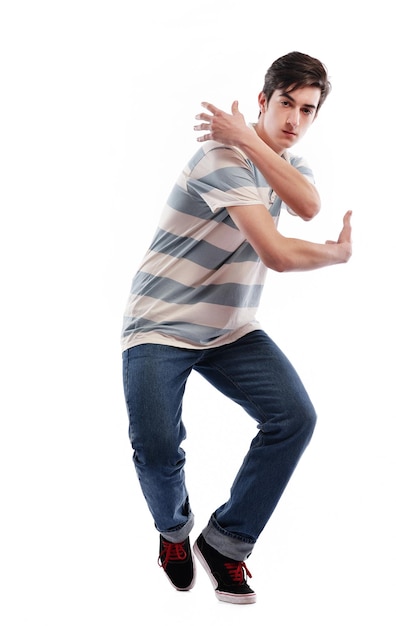 jovem rapaz adolescente dançando e pulando isolado no fundo branco em estúdio