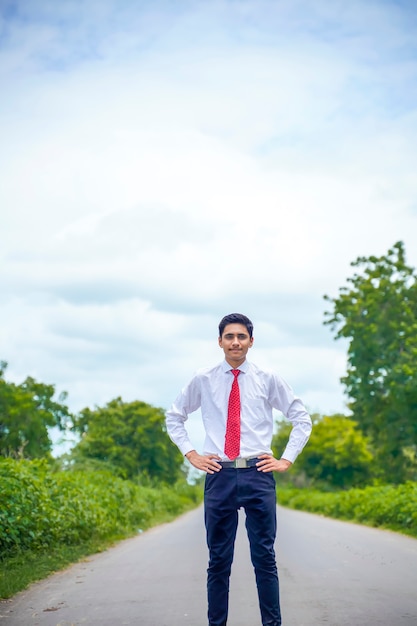 Jovem rapaz asiático / indiano em pé na estrada