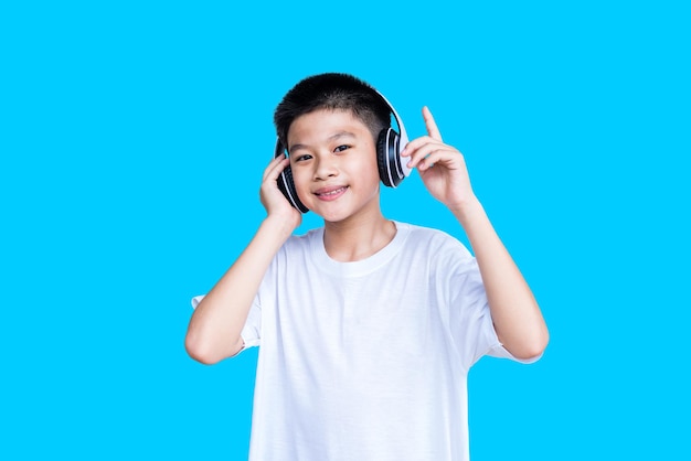 Foto jovem rapaz asiático inteligente com fones de ouvido brancos isolados em um fundo azul