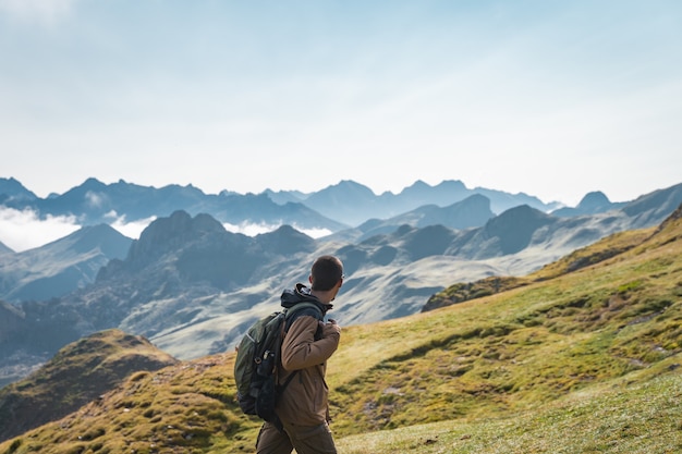 Jovem rapaz aventureiro caminhando pelas altas montanhas Estilo de vida, relaxamento e liberdade