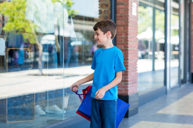 Jovem rapaz brincando com sacolas de compras