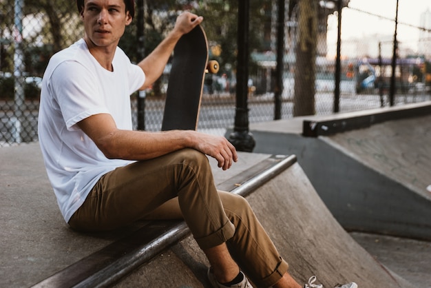 Jovem rapaz realizando truques com o skate em um parque de skate