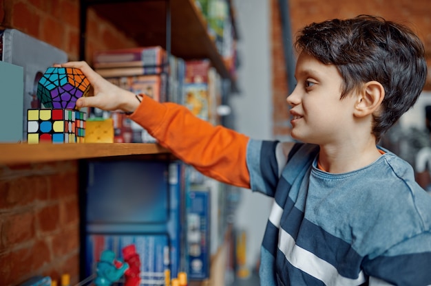 Jovem rapaz tem cubo colorido quebra-cabeça na mão. Brinquedo para o treinamento do cérebro e da mente lógica, jogo criativo, resolução de problemas complexos