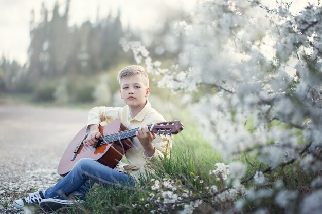 Jovem rapaz tocando guitarra ao ar livre