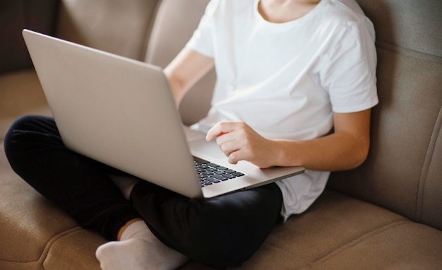 Jovem rapaz usando laptop de perto