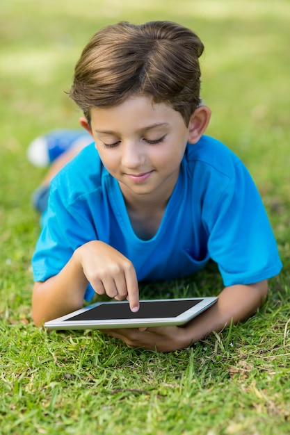 Jovem rapaz usando tablet digital no parque