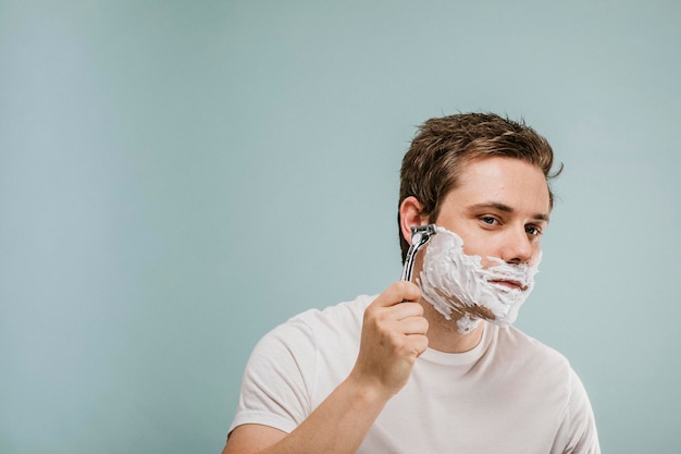 Jovem raspando a barba