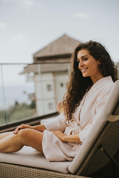 Jovem relaxando na cama no terraço ao ar livre