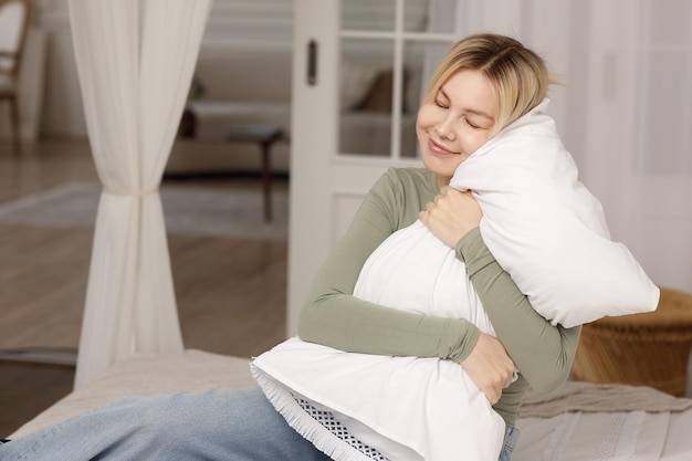 Jovem relaxante abraça travesseiro na cama Sono saudável