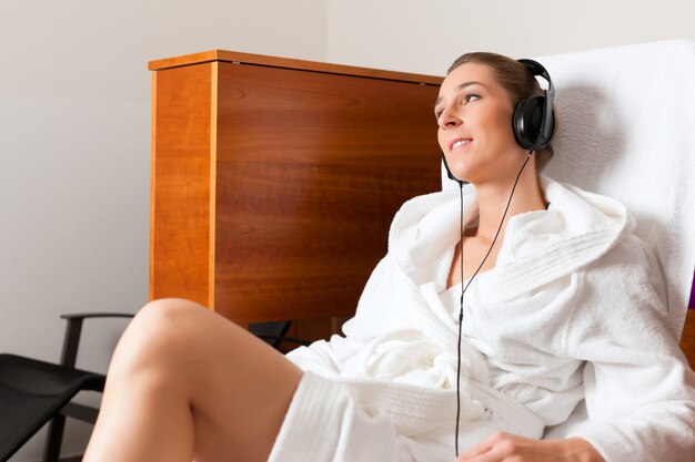 Foto jovem relaxante no spa com música