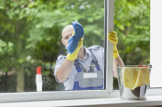 Jovem reparador fixando a moldura da janela no quarto durante o dia