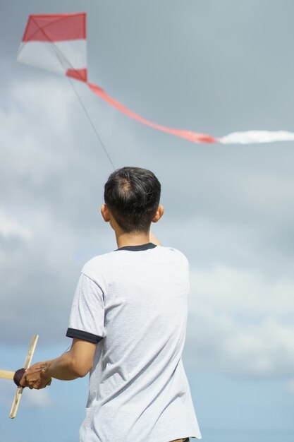 Foto jovem retrato jogando pipa no campo