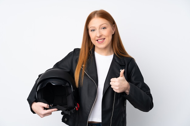 Jovem ruiva com um capacete de moto com polegares para cima, porque algo de bom aconteceu