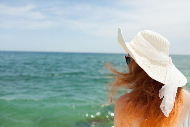 jovem ruiva com um chapéu no fundo do mar