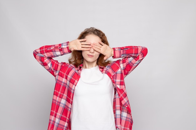 Jovem ruiva com uma camisa xadrez em um fundo branco com um lugar para o texto