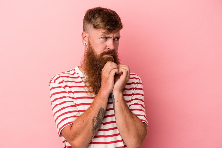 Foto jovem ruivo caucasiano com barba longa, isolado no fundo rosa, inventando o plano em mente, configurando uma ideia.