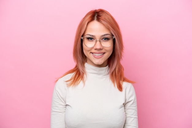 Jovem russa isolada em fundo rosa com óculos com expressão feliz