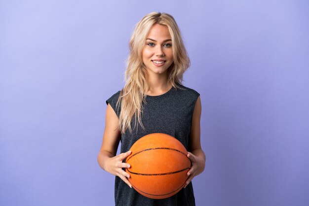 Jovem russa isolada em roxo jogando basquete