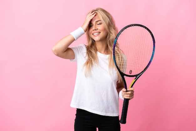 Jovem russa jogando tênis isolada na parede roxa e sorrindo muito