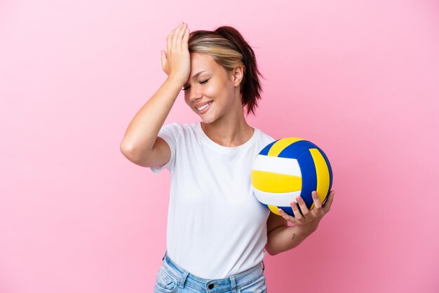 Jovem russa jogando vôlei isolada em fundo rosa percebeu algo e pretende a solução