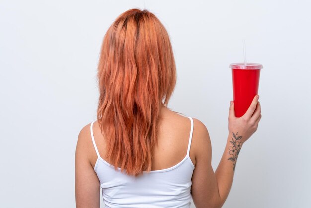 Foto jovem russa segurando refrigerante isolado no fundo branco na posição traseira