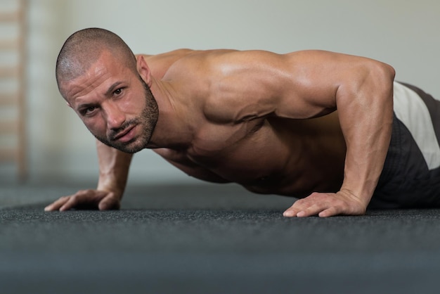 Foto jovem saudável fazendo flexões no chão