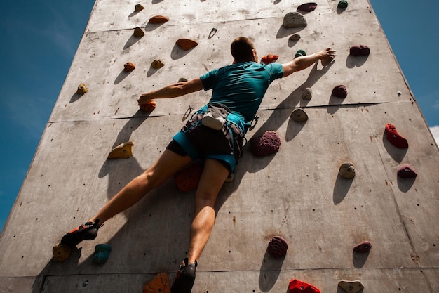 Jovem se exercitando no ginásio de escalada indoor