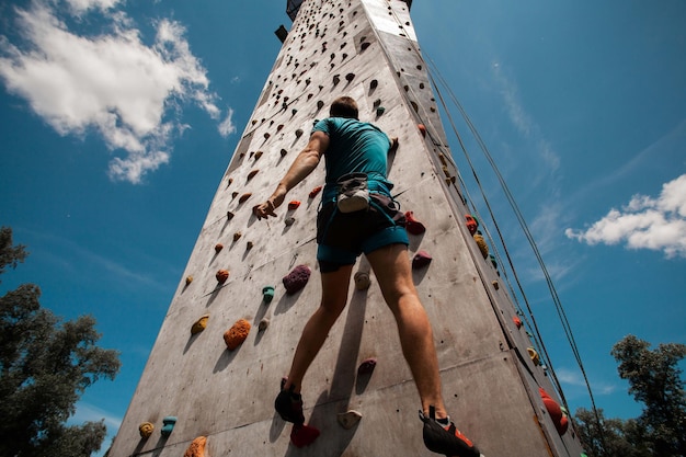 Jovem se exercitando no ginásio de escalada indoor