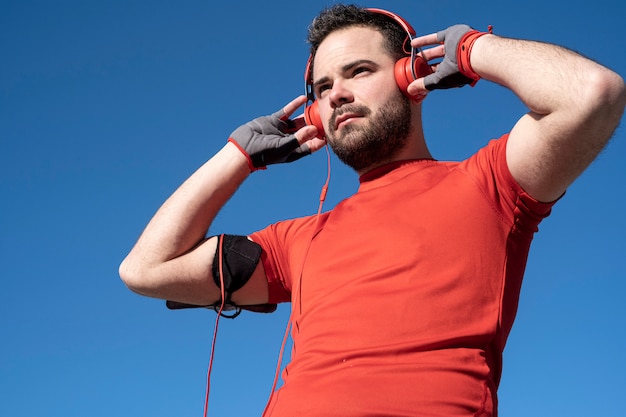 Jovem se preparando para correr com um par de fones de ouvido