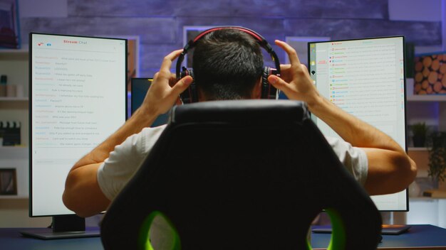 Jovem se preparando para uma sessão de jogo de tiro online. jogador concentrado vindo para sua mesa