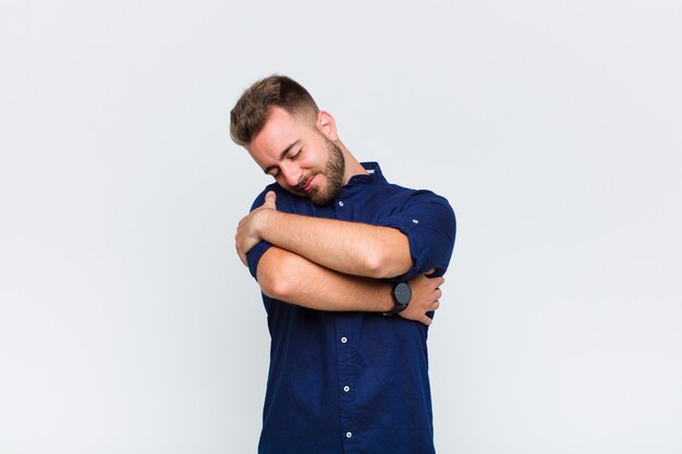 Foto jovem se sentindo apaixonado, sorrindo, acariciando e abraçando a si mesmo, permanecendo solteiro, sendo egoísta e egocêntrico