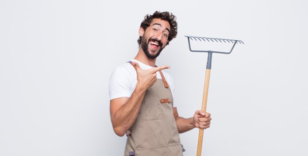 Jovem se sentindo feliz, amigável e positivo, sorrindo e fazendo um retrato ou moldura com as mãos