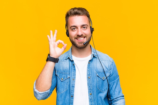 Jovem se sentindo feliz, relaxado e satisfeito, mostrando aprovação com gesto de ok, sorrindo