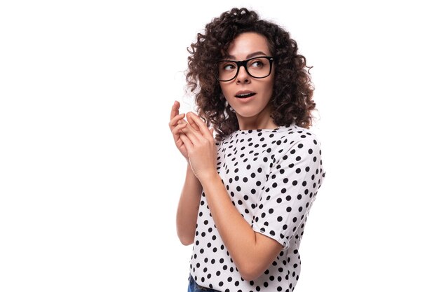 Foto jovem secretária enérgica e encaracolada vestida com uma blusa preta e branca.