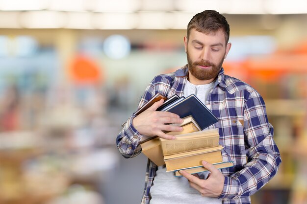 Jovem, segurando a pilha de livros