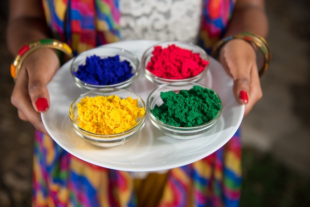 Foto jovem, segurando as cores em pó no prato no festival de cores chamado holi, um popular festival hindu comemorado em toda a índia