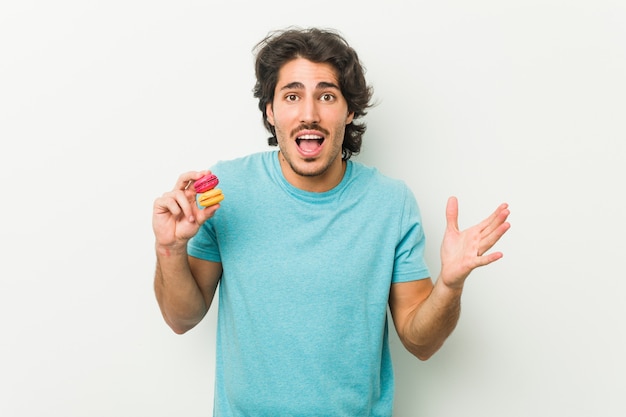 Jovem, segurando biscoitos, comemorando uma vitória ou sucesso