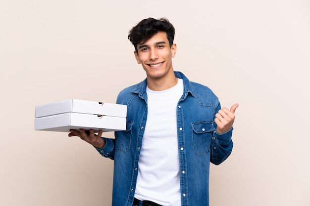 jovem segurando caixas de pizzas parede isolada