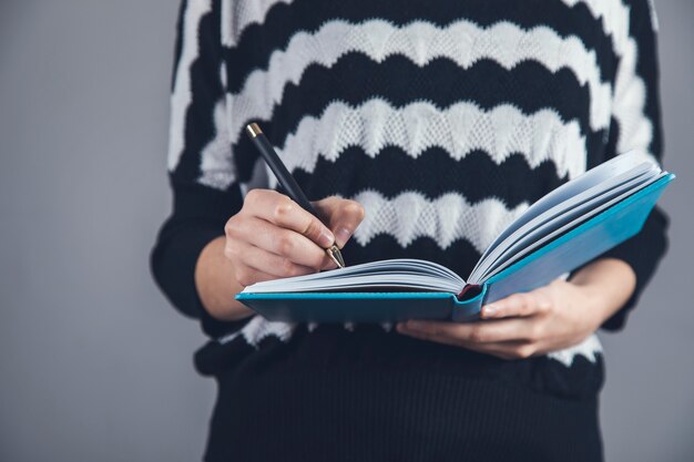 Jovem segurando caneta e caderno