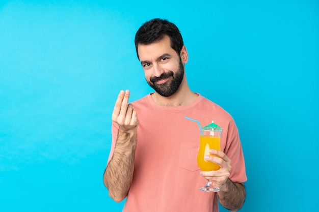 Jovem, segurando, coquetel, isolado, azul, parede, fazendo, dinheiro, gesto